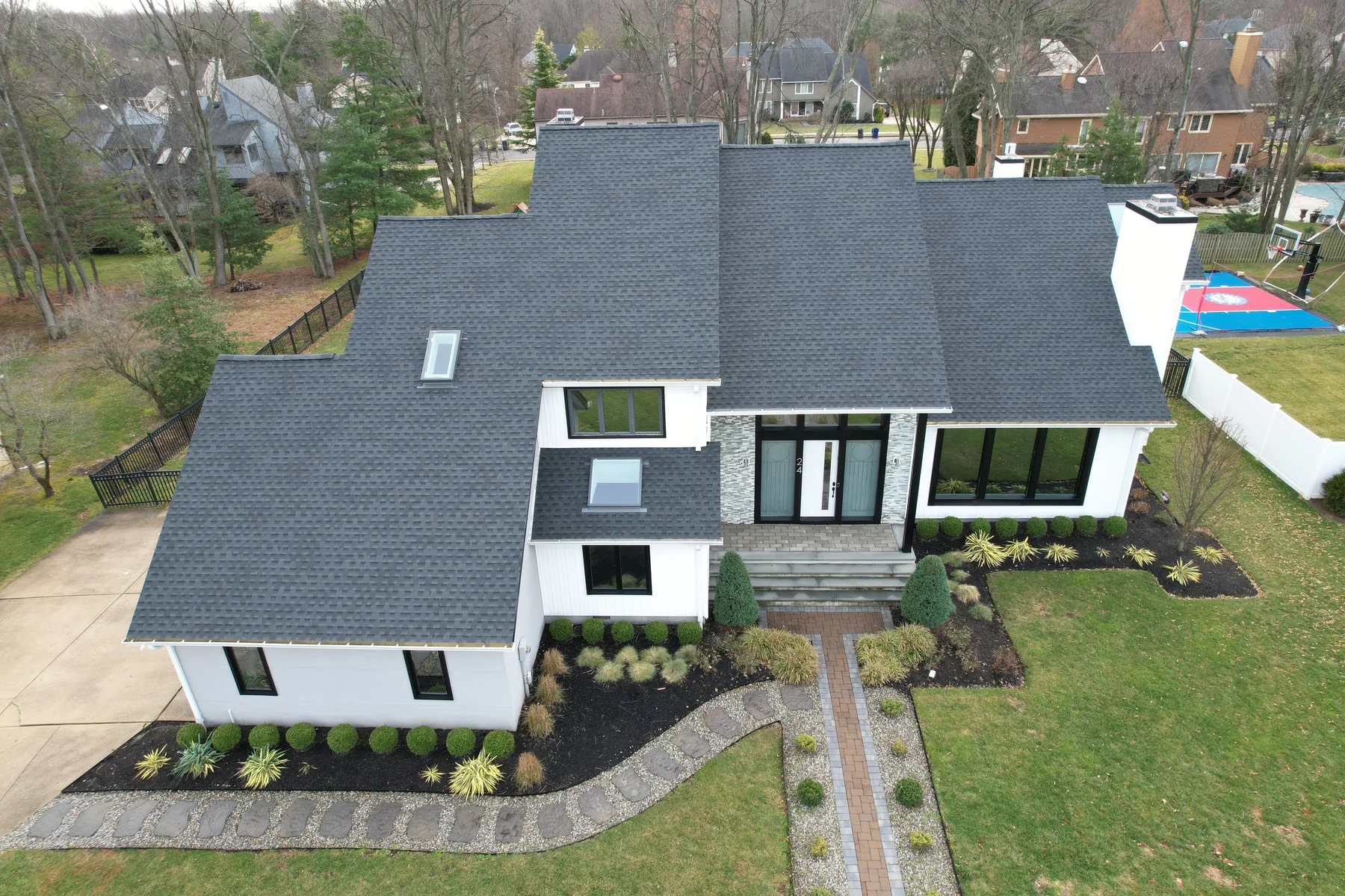 Completed charcoal roof and white exterior restoration by Ultimate Improvements