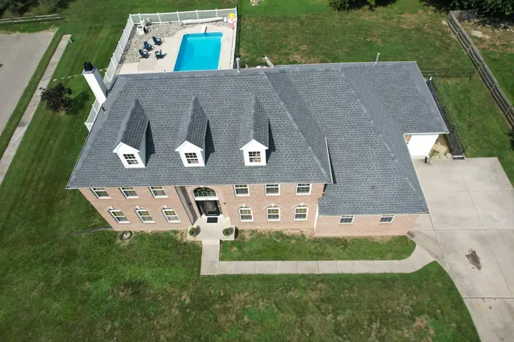 Large brick home with a completed gray roof