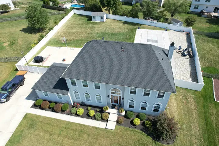 Completed gray roof on a large white two-story home