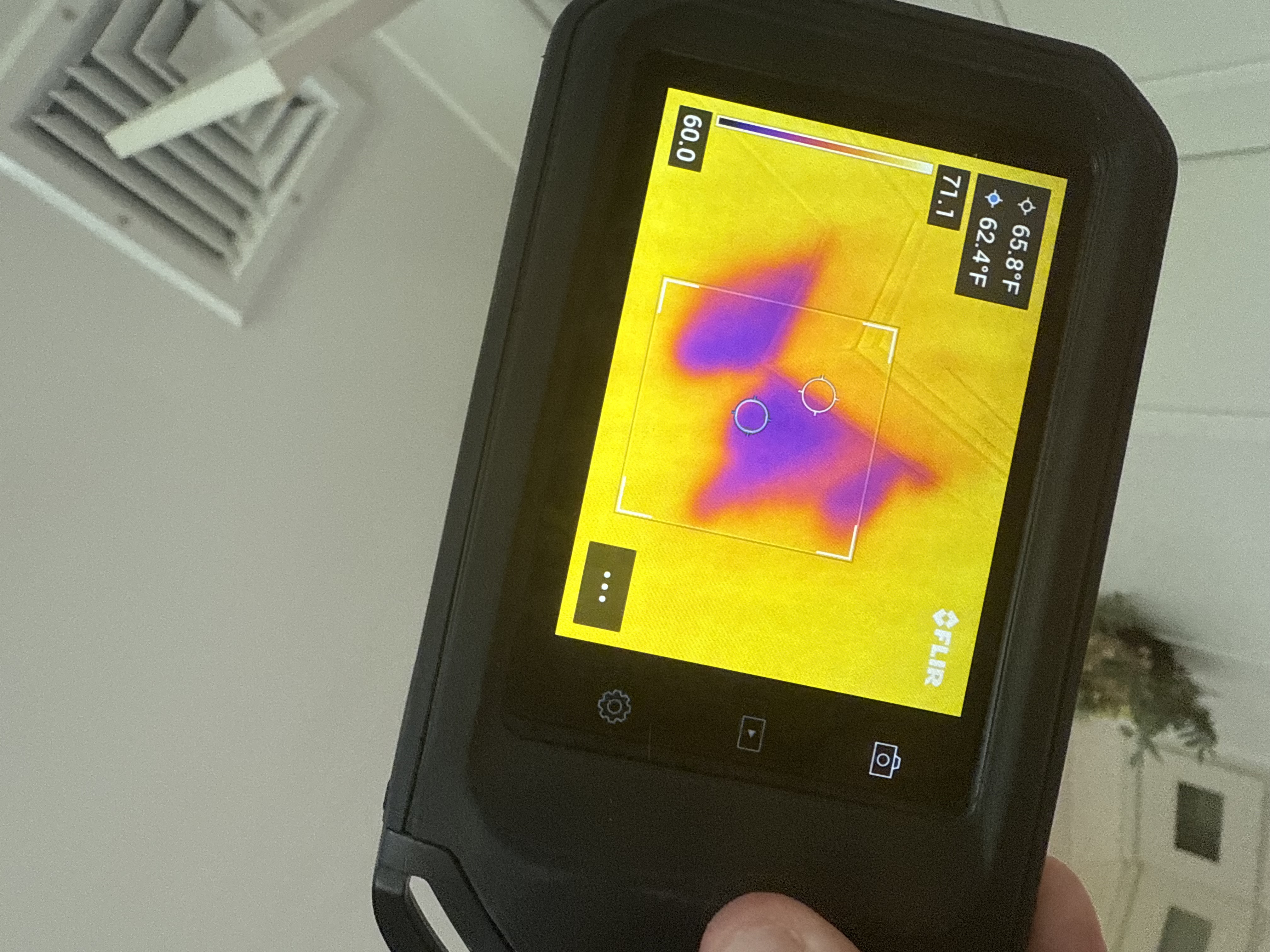 Technician using a thermal imaging camera during a water intrusion inspection
